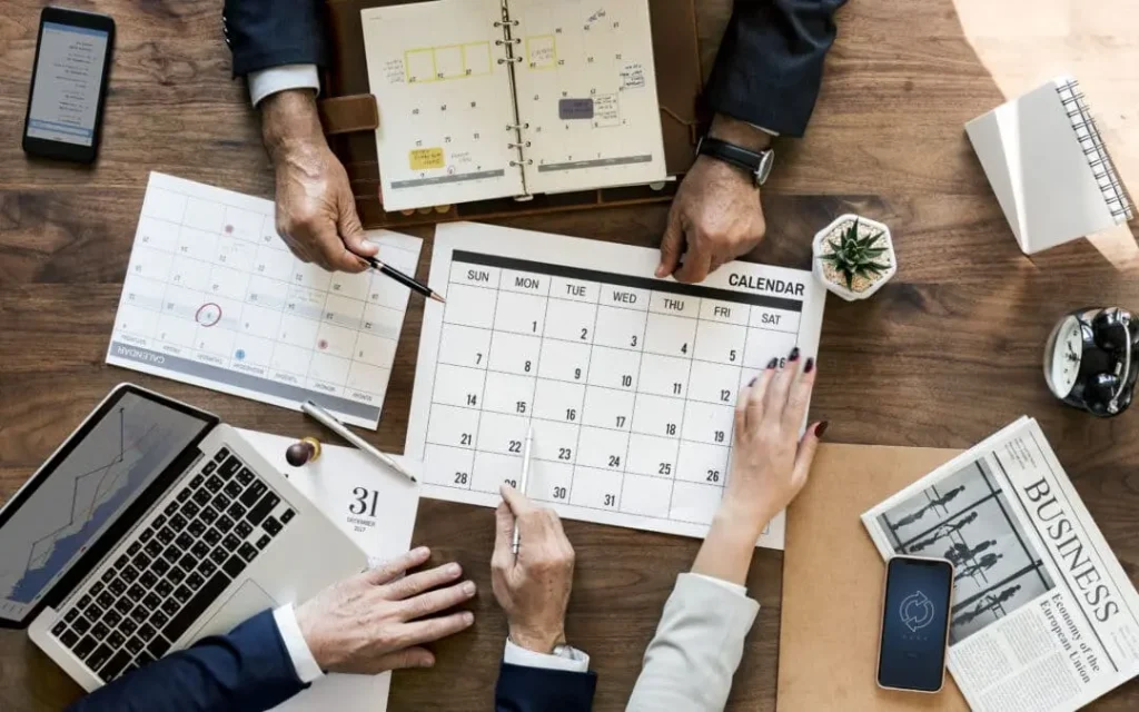 pessoas reunidas verificando o calendário para saber sobre o trabalho aos domingos