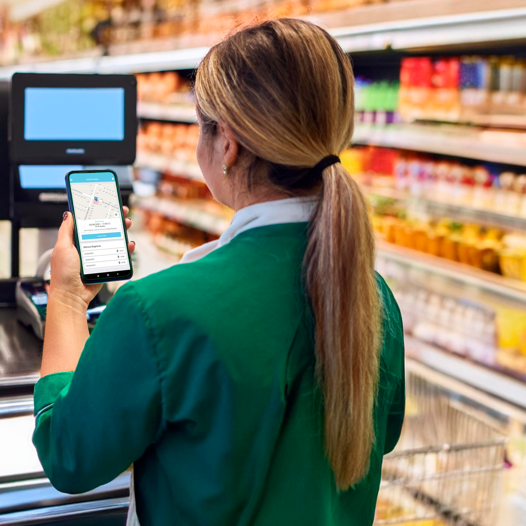 Mulher trabalhando em caixa de supermercado realizando o registro de ponto por aplicativo de celular do software da Ponto Tecnologia